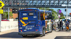 A Denver RTD Flatiron Flyer bus, unit 3621, on route FF1, loads passengers at a bus ramp station beneath a pedestrian overpass.