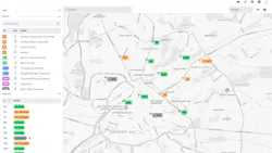 A screenshot of Optibus's Real-Time Suite dashboard shows a map of Manchester, England, with color-coded bus markers and side panels listing routes and vehicle statuses such as 'on time' and '8m delayed.'