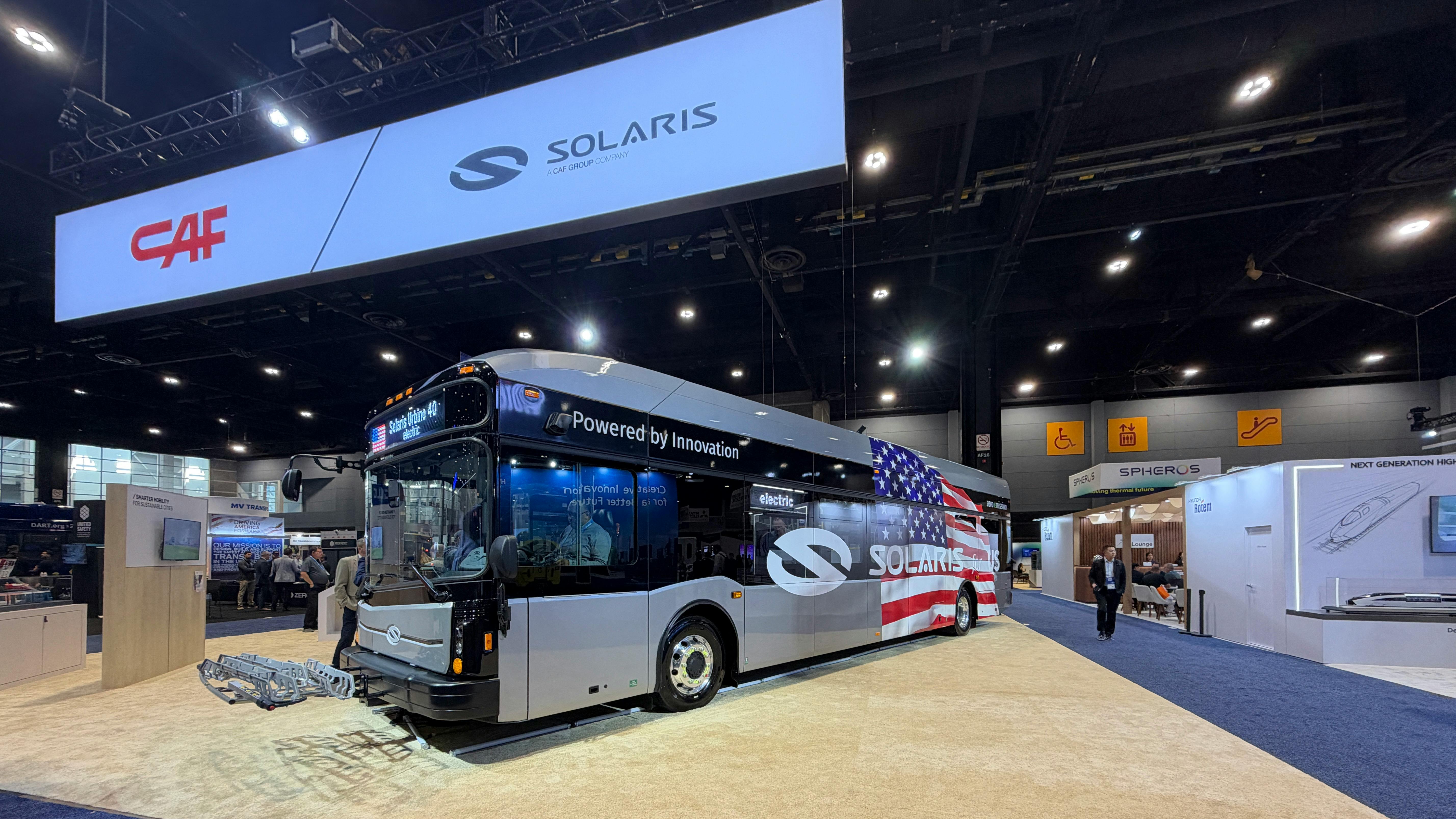 The new Solaris Urbino 40-foot electric bus sits on the APTA EXPO show floor beneath signage for parent-company CAR and Solaris.