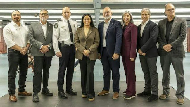 Eight people stand in a row for a group photo indoors, including a uniformed police official, with Aydin Matlabi, Jim Beis, C&eacute;dric Couture, Soraya Martinez Ferrada, Aref Salem, Marie-Claude L&eacute;onard, Martin Prud&rsquo;homme and Guy Langlois pictured left to right.