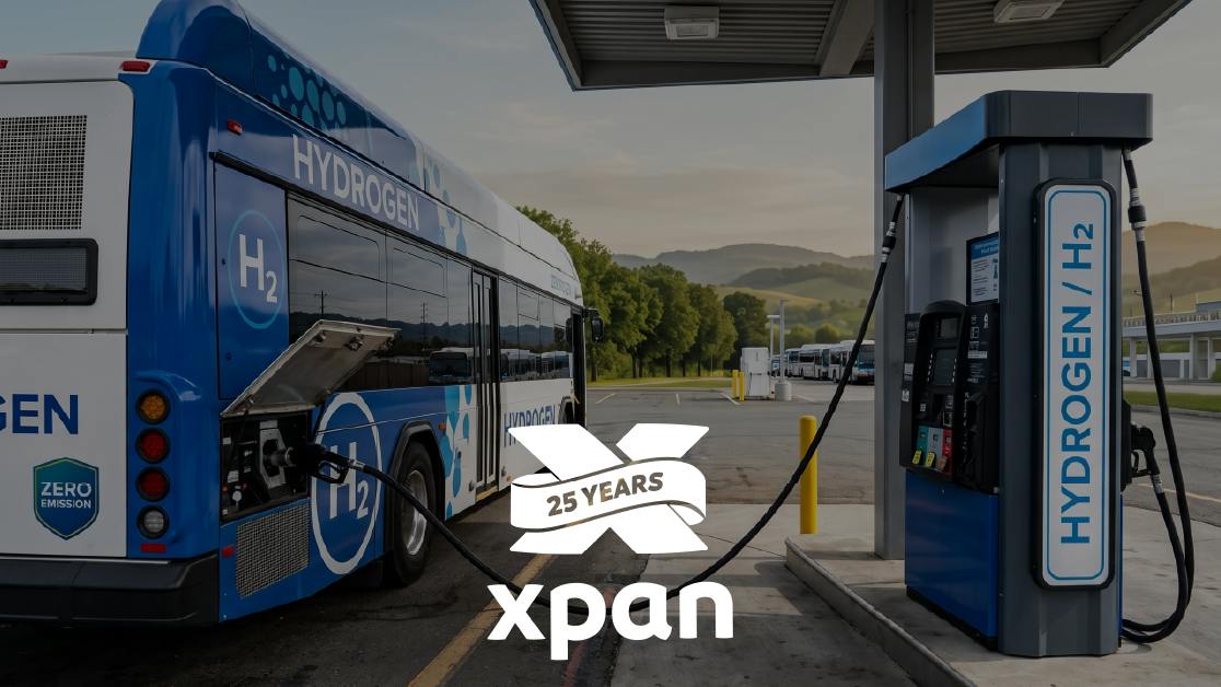 A blue and white hydrogen fuel cell bus with &ldquo;Hydrogen,&rdquo; &ldquo;H2&rdquo; and &ldquo;Zero Emission&rdquo; markings is connected to a hydrogen dispenser under a fueling canopy, with a Xpan &ldquo;25 Years&rdquo; logo overlaid on the lower center of the image.